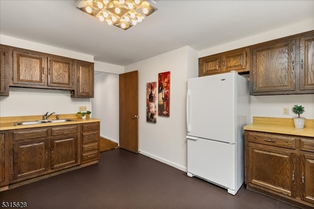 kitchen featuring white fridge, sink, and an inviting chandelier