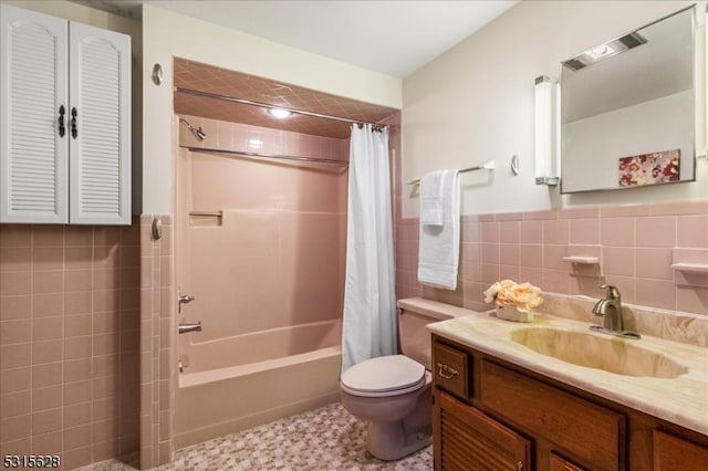 full bathroom with shower / bath combo with shower curtain, vanity, tile walls, and toilet