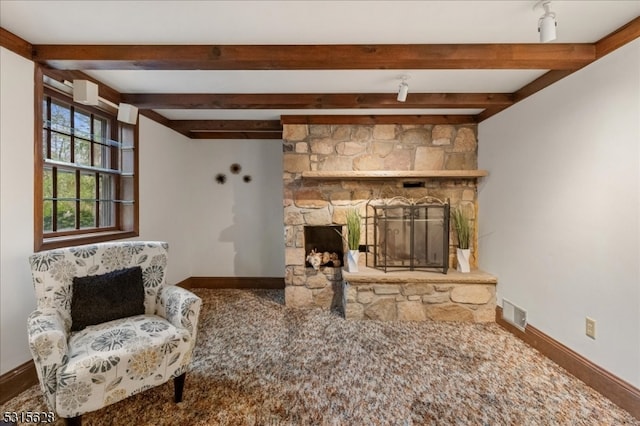 living room with beam ceiling, a fireplace, and carpet