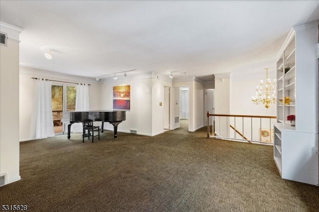 empty room featuring an inviting chandelier, rail lighting, ornamental molding, and dark colored carpet