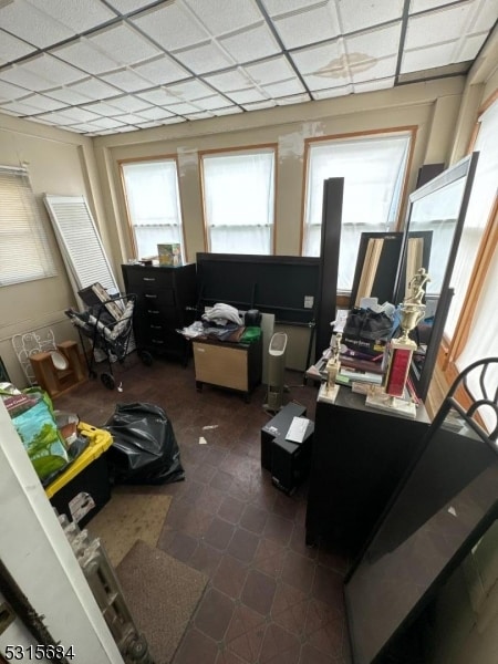 miscellaneous room featuring dark tile patterned floors and a paneled ceiling