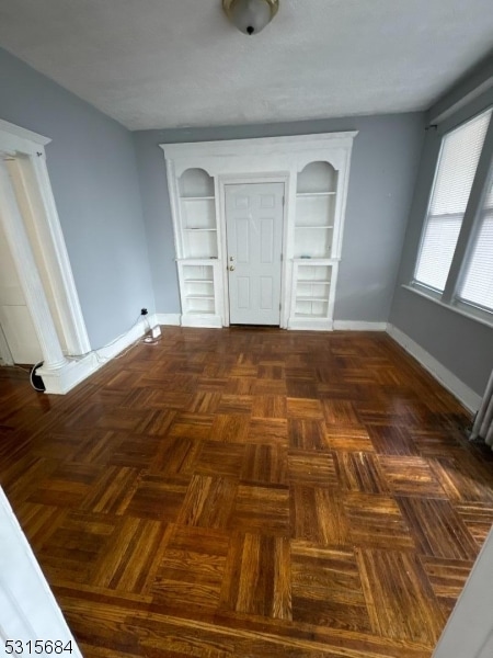 unfurnished bedroom with dark parquet floors