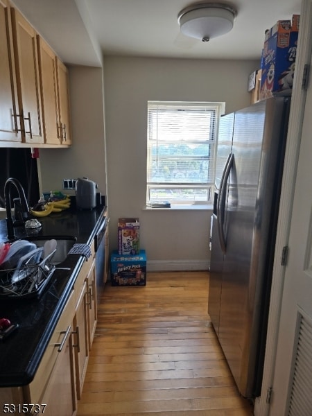 kitchen with appliances with stainless steel finishes, light hardwood / wood-style floors, and sink