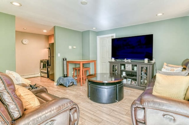 living room with light hardwood / wood-style floors and a baseboard heating unit