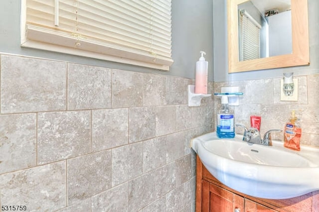 bathroom featuring vanity and tile walls