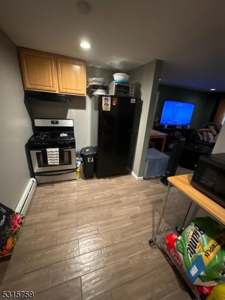 kitchen featuring light brown cabinets, black fridge, baseboard heating, stainless steel gas range, and light wood-type flooring