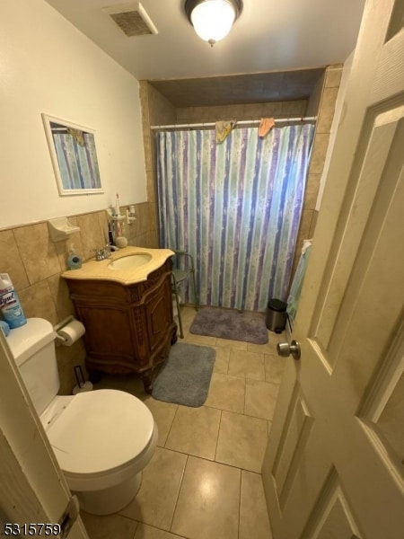 bathroom with vanity, toilet, tile walls, and a shower with shower curtain