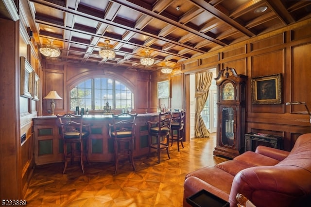 bar featuring light parquet flooring, coffered ceiling, wooden walls, and beamed ceiling