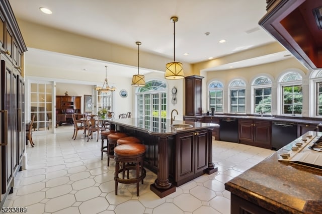 kitchen with a kitchen breakfast bar, hanging light fixtures, black dishwasher, and dark brown cabinets