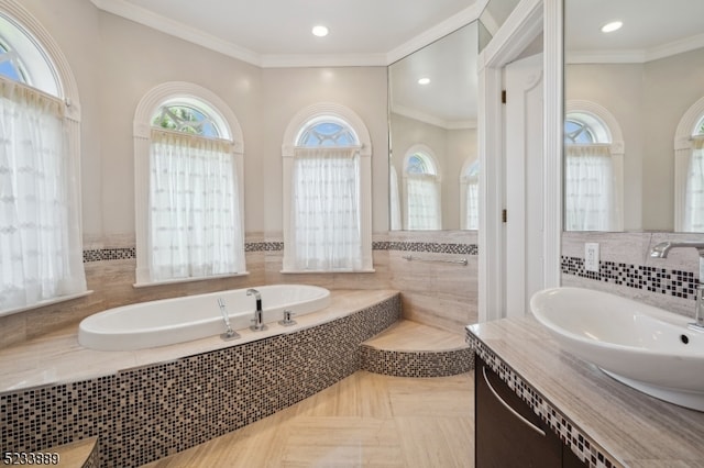 bathroom featuring ornamental molding, tiled tub, and vanity