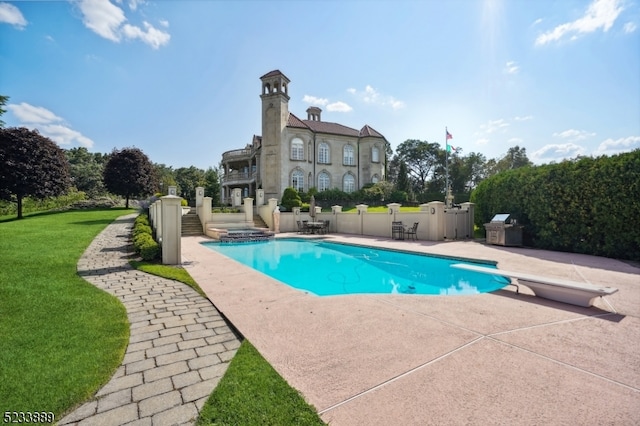 view of swimming pool with a diving board and a patio area