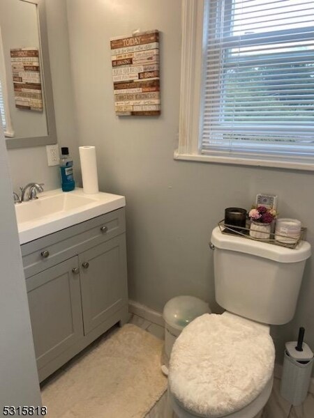 bathroom with tile patterned flooring, vanity, and toilet