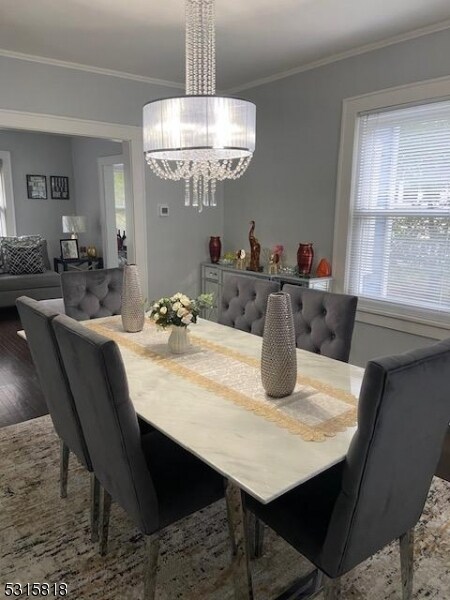 dining room with hardwood / wood-style floors and crown molding