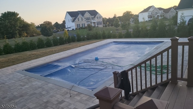 pool at dusk featuring a patio area