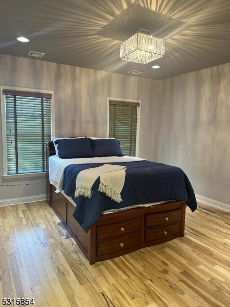 bedroom featuring a chandelier and light hardwood / wood-style flooring