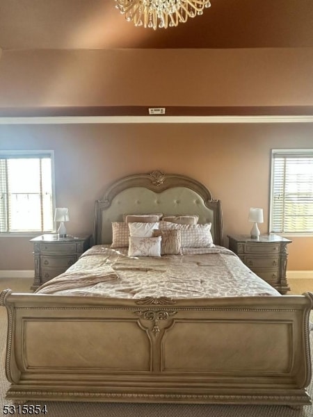 carpeted bedroom with a notable chandelier