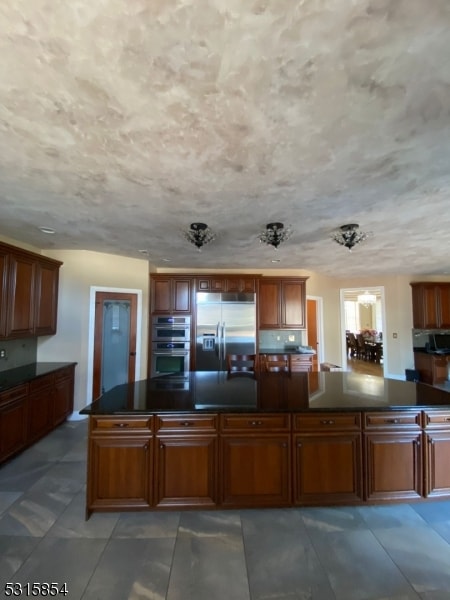 kitchen featuring a kitchen island, stainless steel appliances, and a textured ceiling