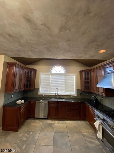 kitchen featuring light tile patterned floors, range hood, sink, and appliances with stainless steel finishes