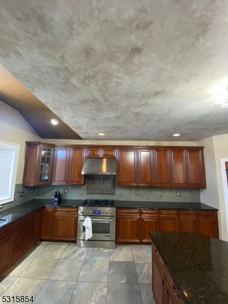 kitchen with high end stainless steel range oven and dark stone counters