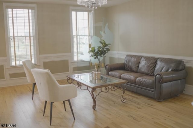 living room featuring a notable chandelier, light wood-type flooring, and a wealth of natural light