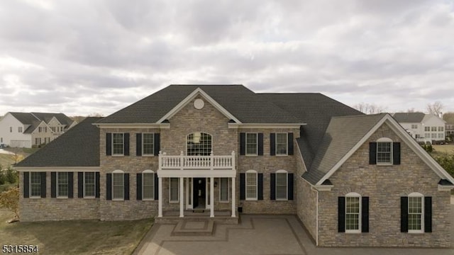 colonial inspired home featuring a patio and a balcony