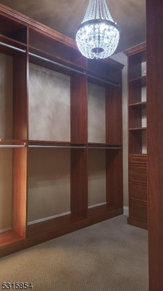 spacious closet featuring carpet and an inviting chandelier