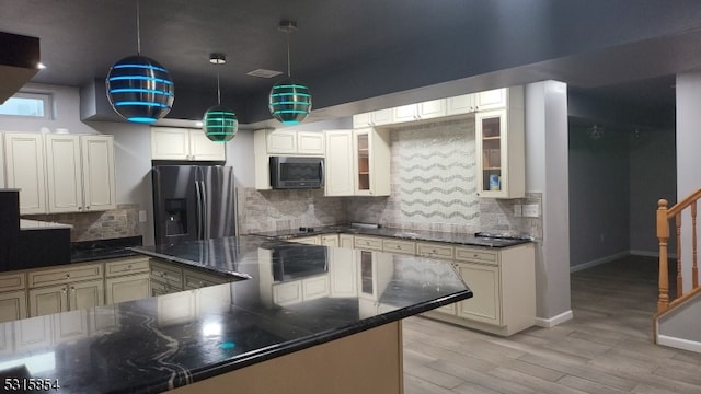 kitchen with tasteful backsplash, light hardwood / wood-style flooring, stainless steel appliances, and decorative light fixtures