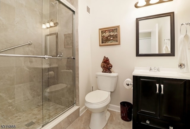 bathroom featuring tile patterned flooring, vanity, toilet, and a shower with door