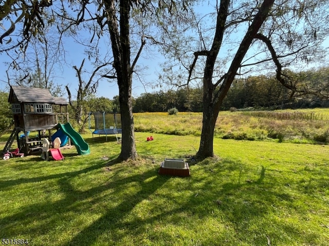 view of yard with a playground and a trampoline