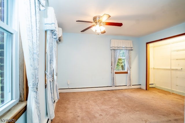 carpeted spare room with ceiling fan, a wall unit AC, and a baseboard radiator