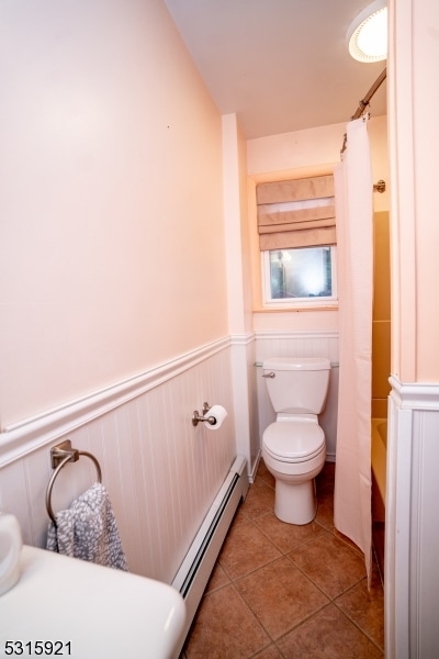 bathroom with toilet, baseboard heating, tile patterned flooring, and shower / bath combination with curtain