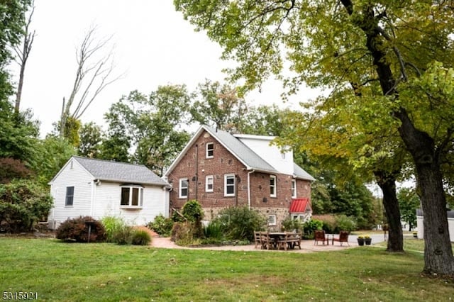 back of house with a lawn and a patio area