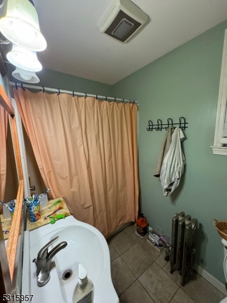 bathroom featuring sink, radiator heating unit, and tile patterned floors