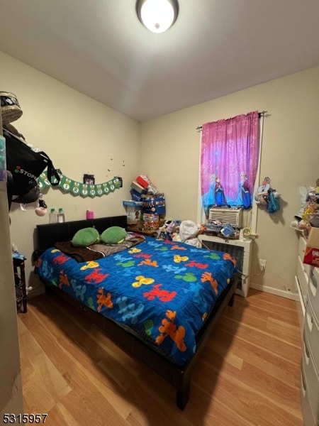 bedroom featuring cooling unit and light hardwood / wood-style floors