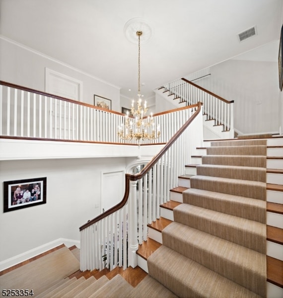 staircase with an inviting chandelier and hardwood / wood-style flooring