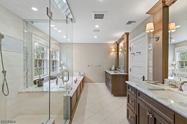 bathroom featuring tile patterned flooring, vanity, and plus walk in shower