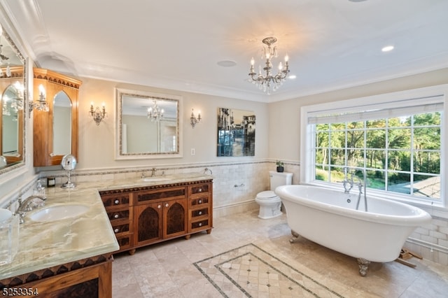 bathroom with tile walls, vanity, toilet, and a tub