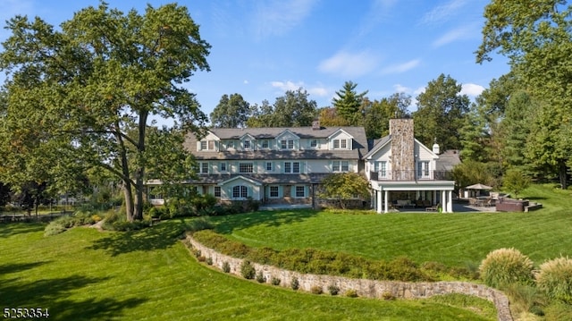 back of property with a yard and a patio area