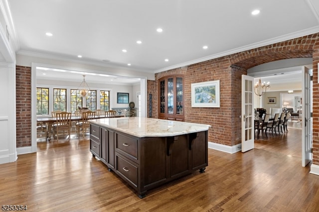 kitchen with dark hardwood / wood-style floors, a center island, and brick wall