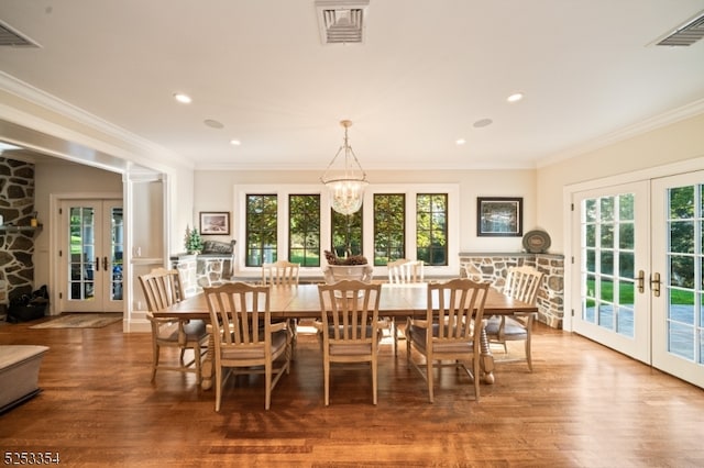 dining room with french doors, a notable chandelier, plenty of natural light, and wood-type flooring