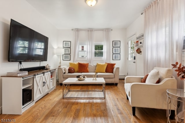 living room featuring light hardwood / wood-style floors and a baseboard heating unit