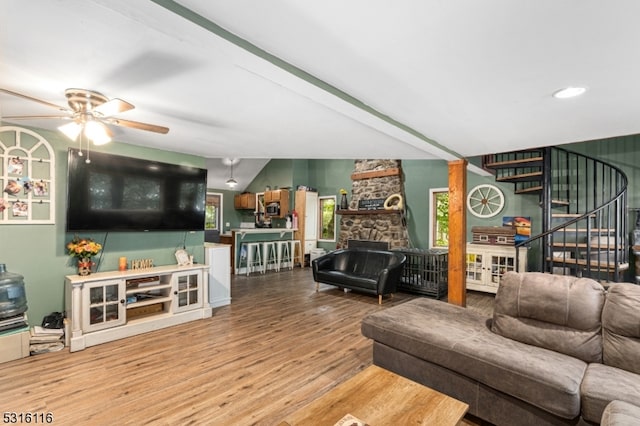 living room featuring a fireplace, vaulted ceiling, hardwood / wood-style floors, and ceiling fan