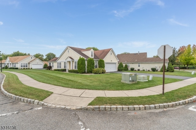 new england style home featuring a garage and a front lawn