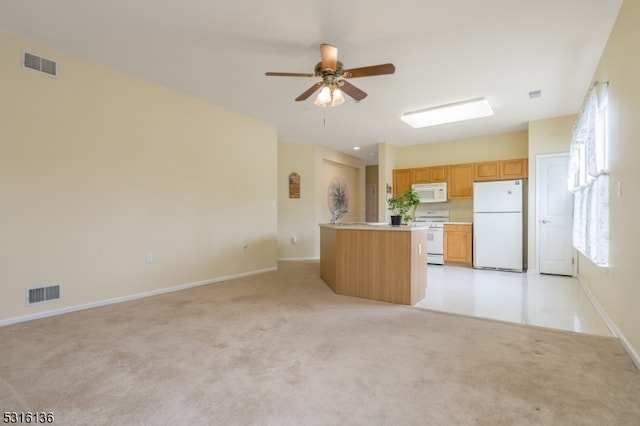 kitchen with white appliances, ceiling fan, a center island, and light colored carpet