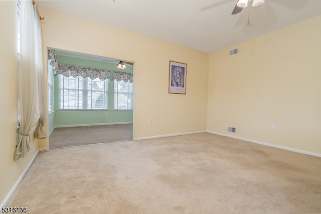 unfurnished room featuring ceiling fan and light colored carpet