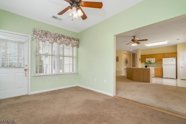 unfurnished living room featuring ceiling fan and light colored carpet