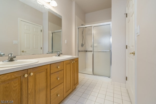 bathroom featuring tile patterned floors, a shower with shower door, and vanity