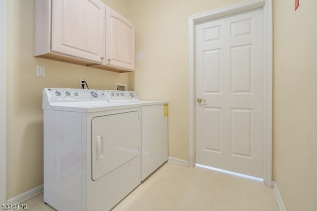 clothes washing area with cabinets and independent washer and dryer