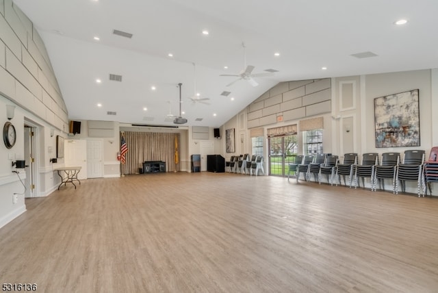 exercise room with light wood-type flooring, ceiling fan, and high vaulted ceiling