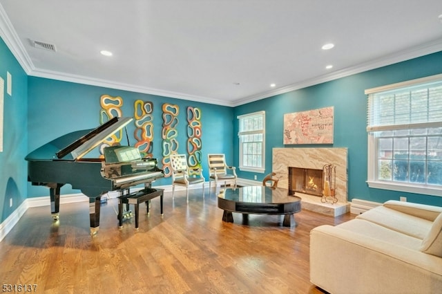 interior space featuring a high end fireplace, ornamental molding, and hardwood / wood-style floors